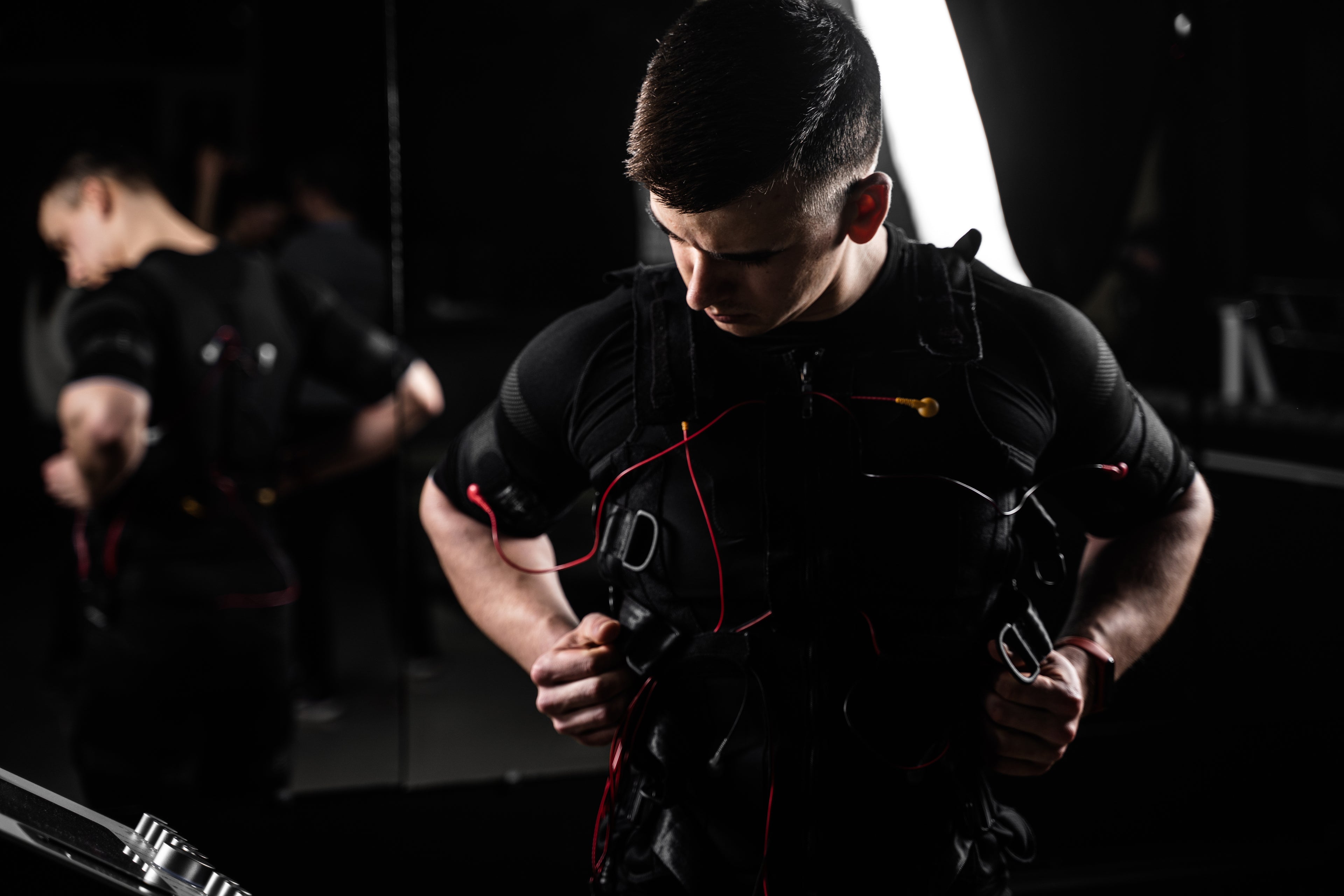EMS electric muscle stimulator suit worn by man during gym training