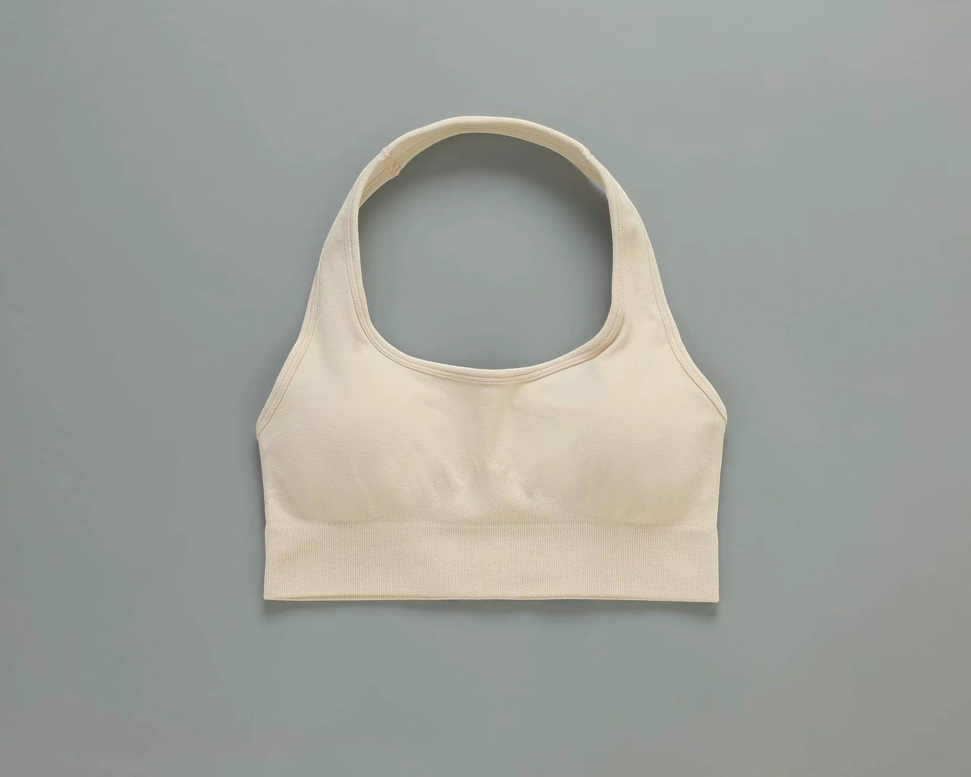 MotionMade beige seamless push-up sports bra with a racerback design for yoga and high-intensity gym workouts.