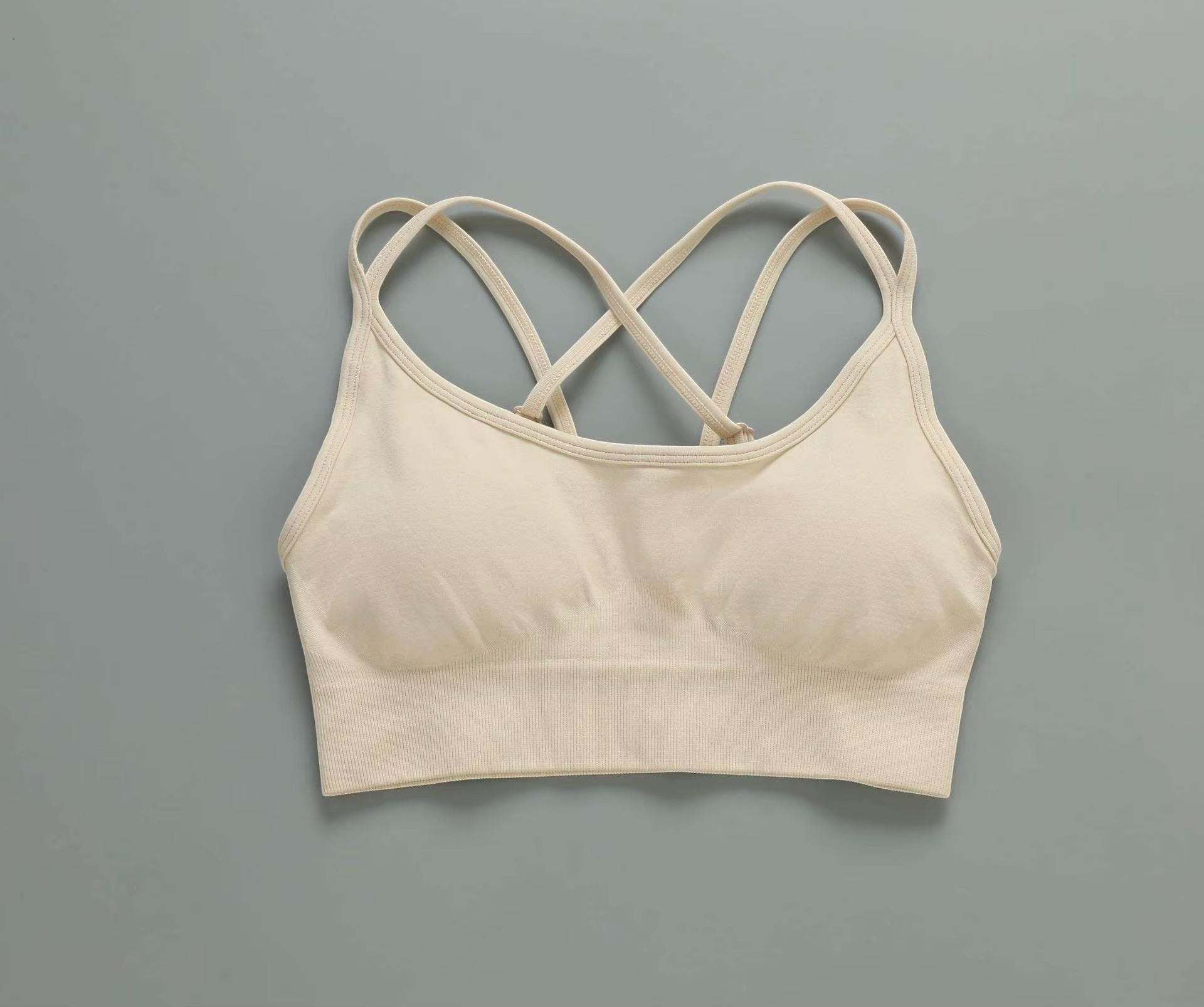 MotionMade beige seamless push-up sports bra with crisscross back straps for yoga and gym workouts.