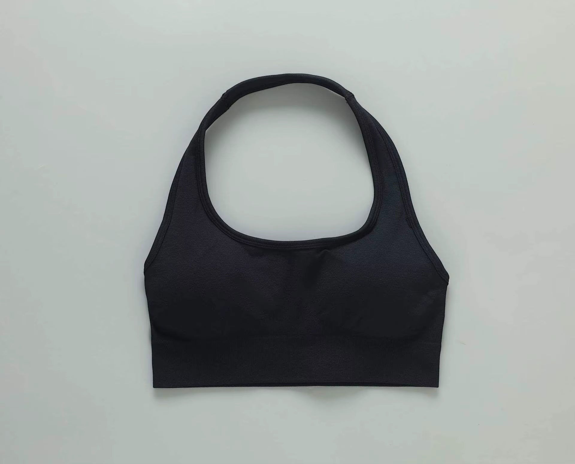 MotionMade black push-up sports bra with a halter neckline, made from moisture-wicking four-way stretch fabric.