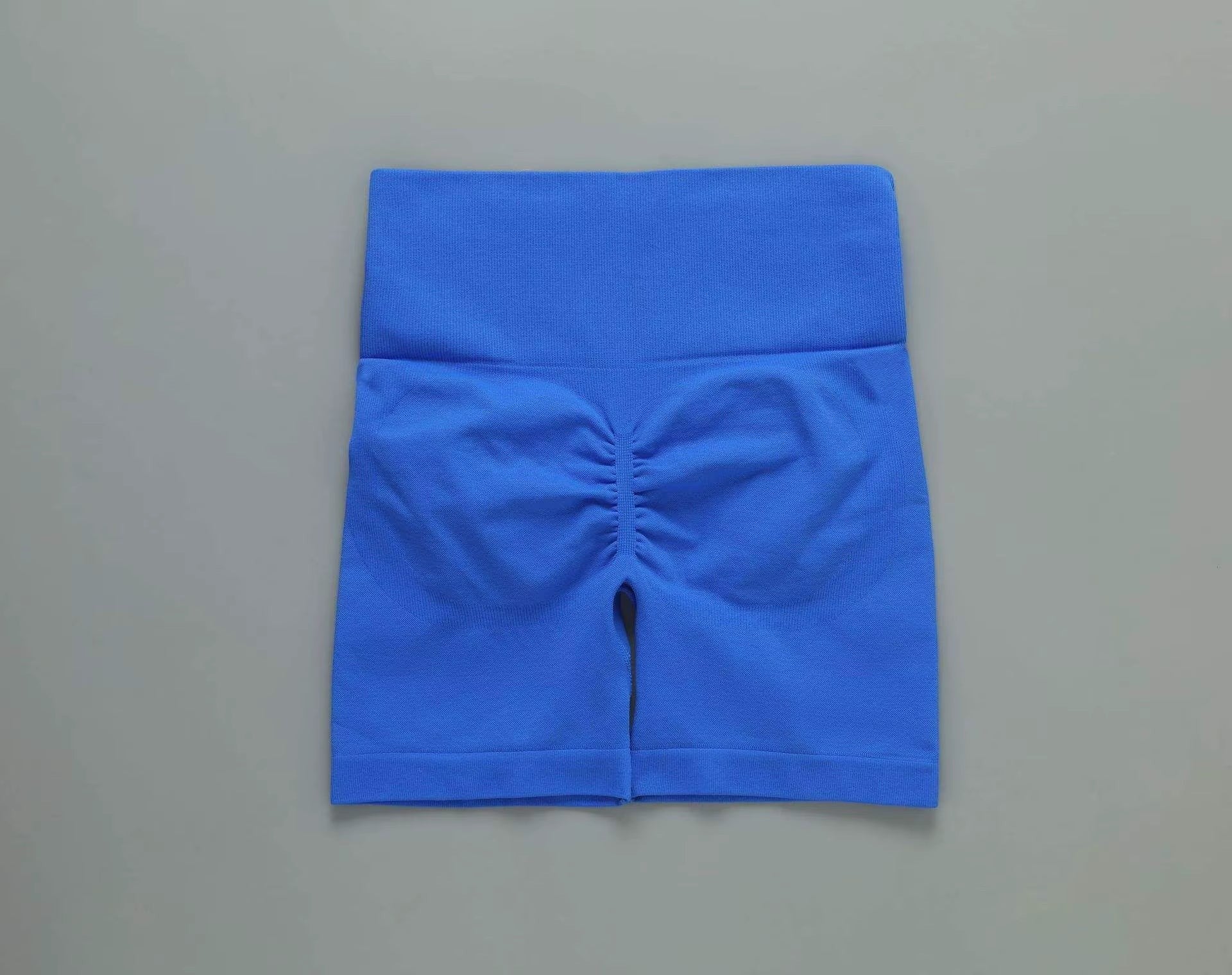 MotionMade blue high-waisted workout shorts with push-up scrunch detail for yoga and gym training.