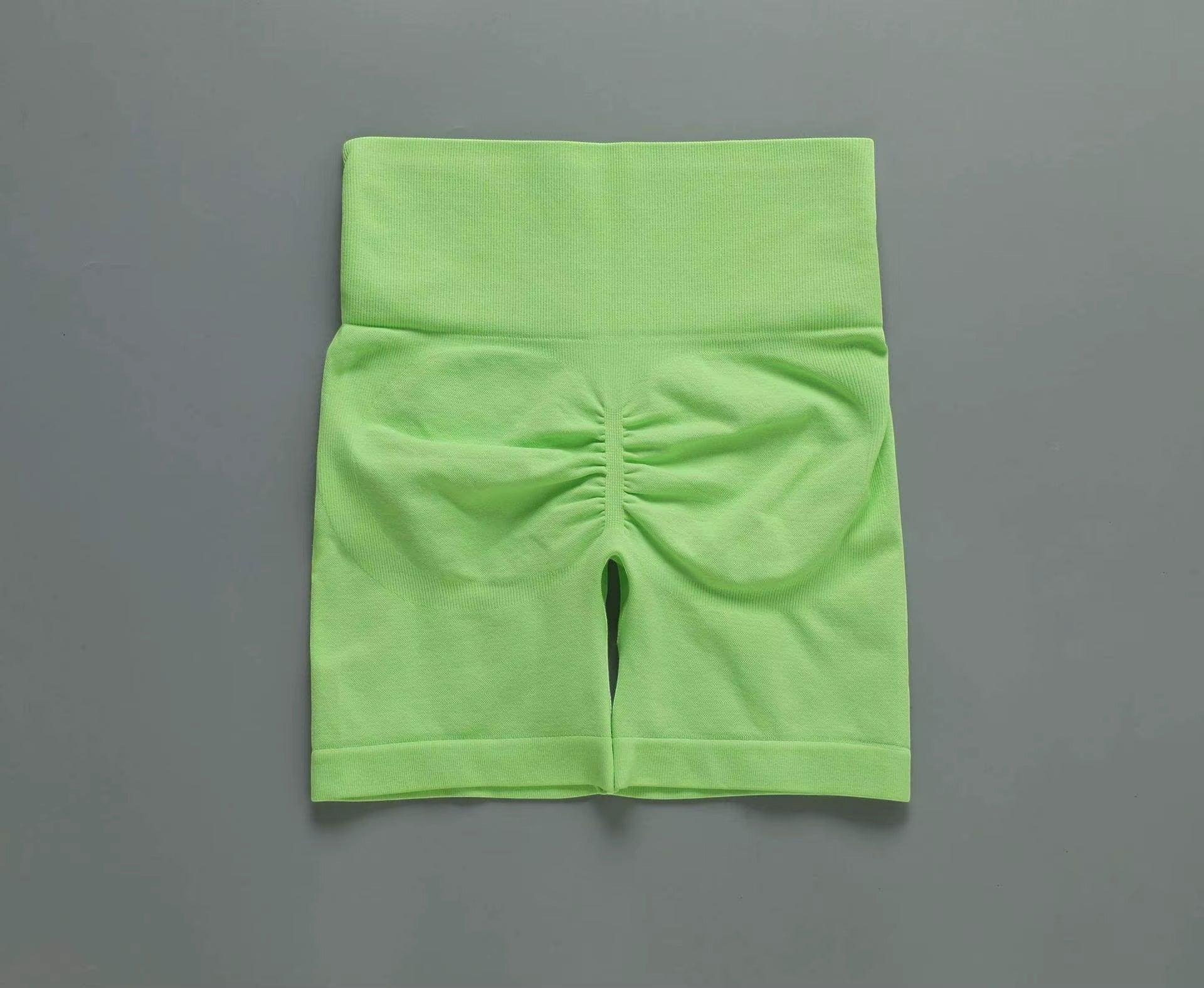 MotionMade lime green high-waisted seamless workout shorts with scrunch-back push-up design for yoga and gym training.