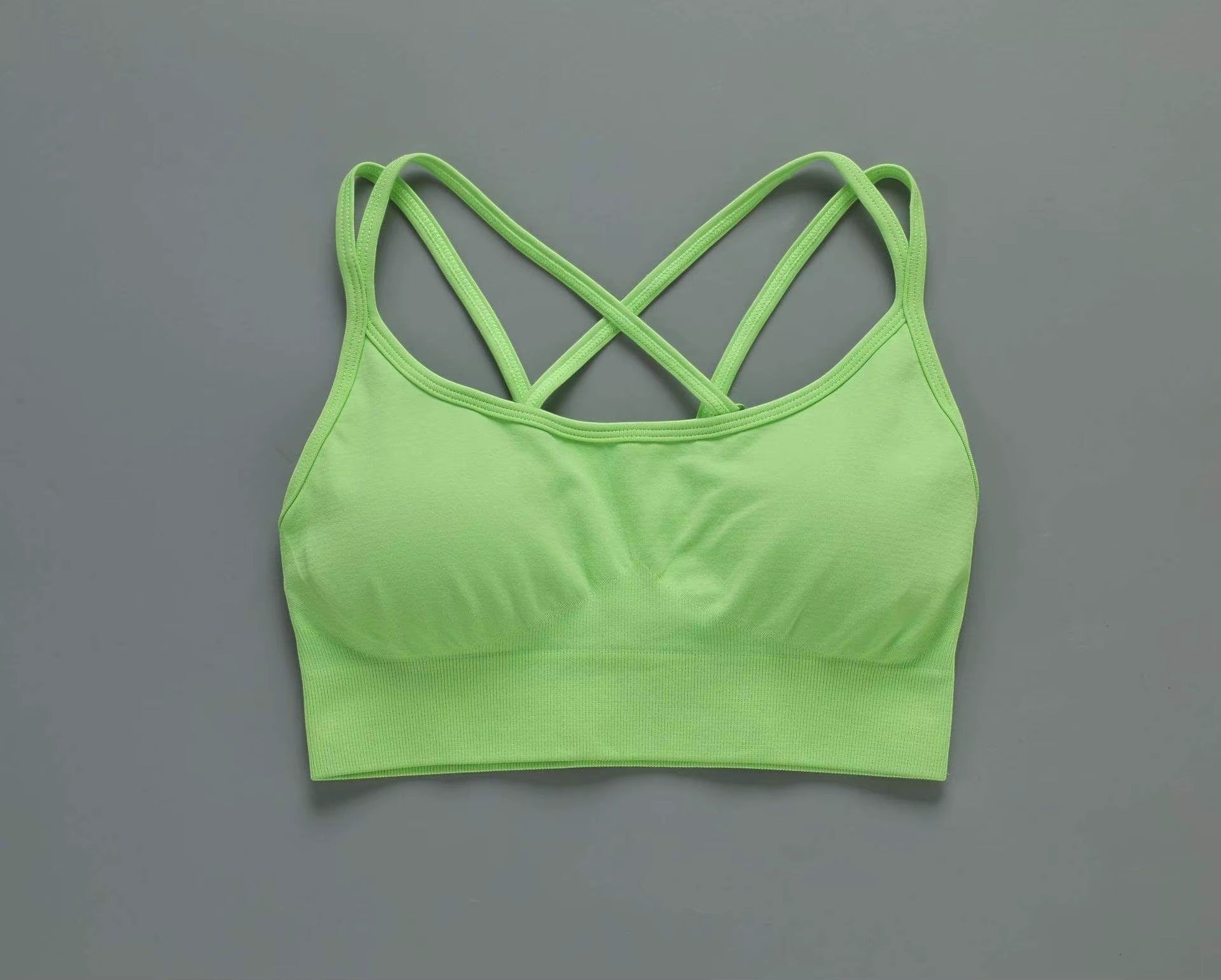 MotionMade lime green push-up sports bra with cross-back straps and moisture-wicking fabric for yoga and gym workouts.