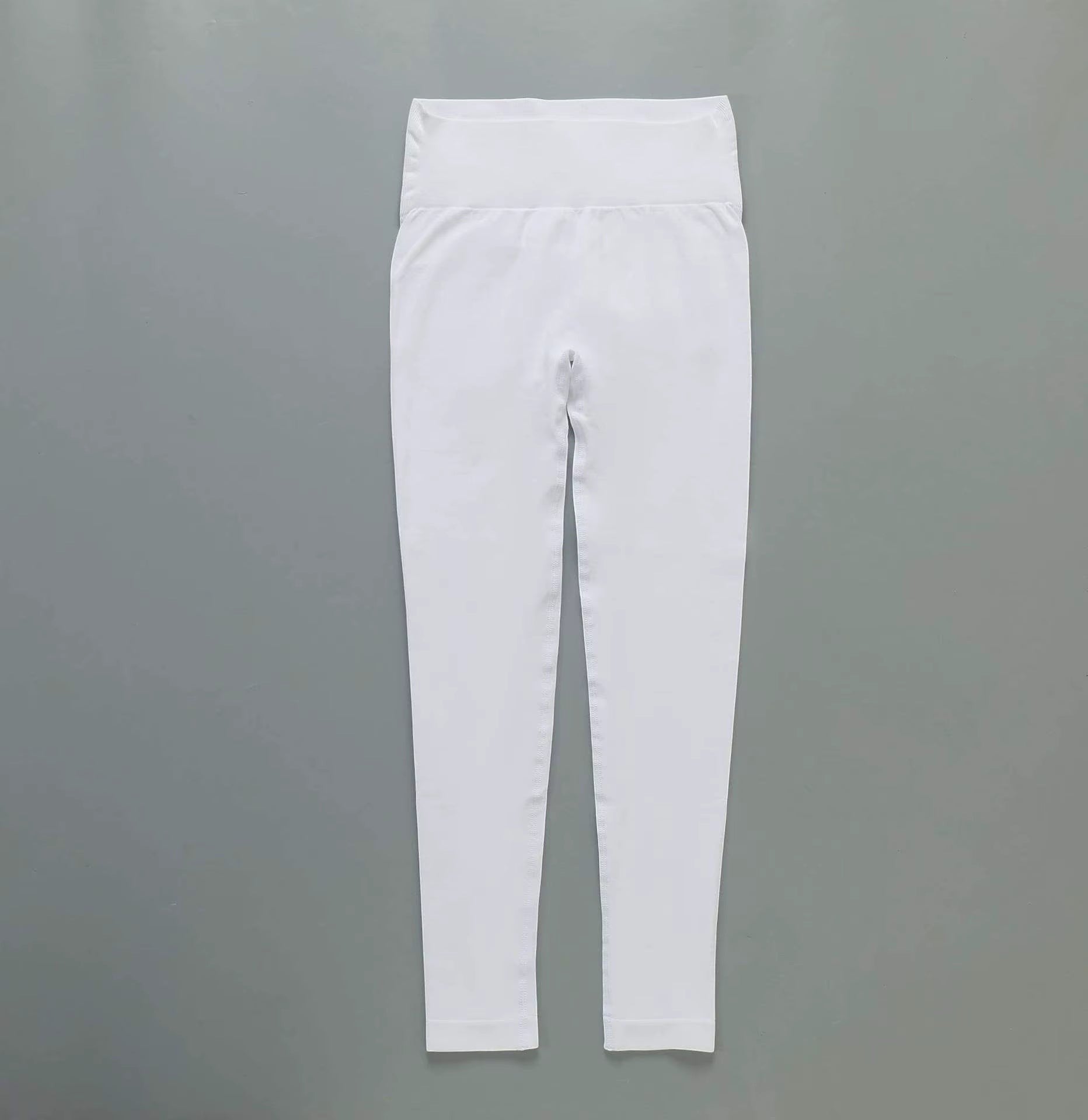 MotionMade white high-waisted yoga leggings with moisture-wicking four-way stretch fabric for gym and fitness training.