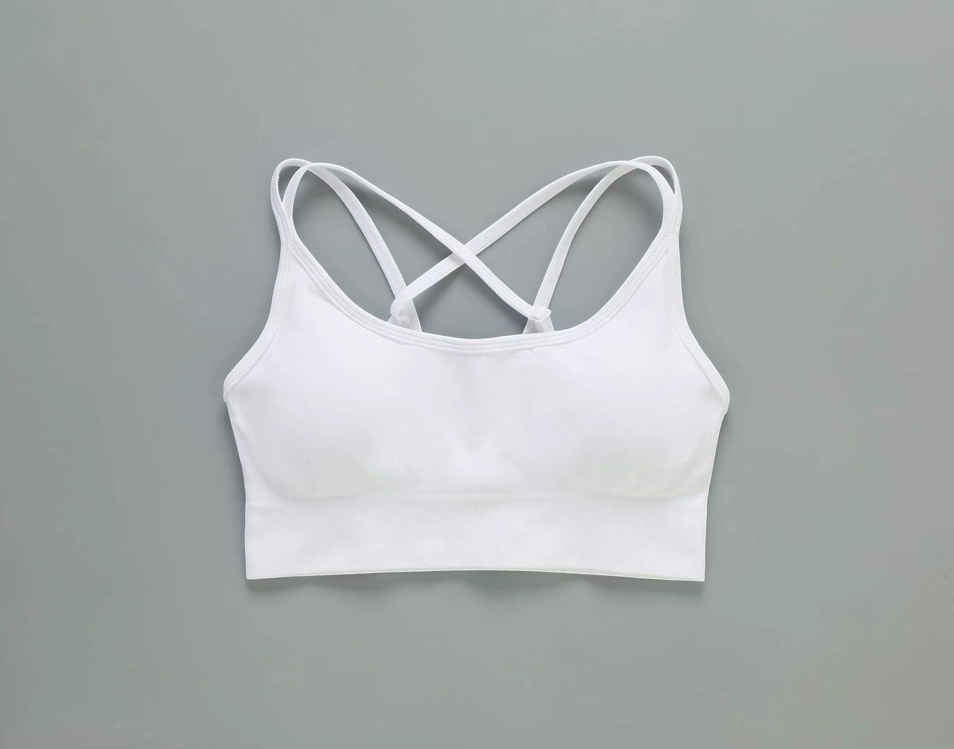 MotionMade white push-up sports bra with cross-back straps for yoga and gym workouts.